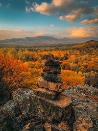 Stack of rocks on land against sky during sunset