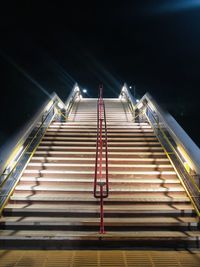 Low angle view of illuminated staircase against sky at night