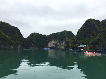 Scenic view of sea by mountains against sky
