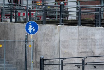 Road sign by railing in city