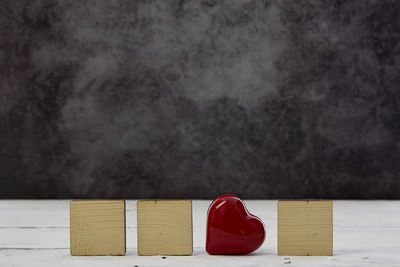 Close-up of heart shape on table against wall