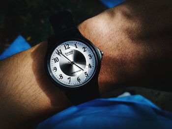 Close-up of human hand holding clock