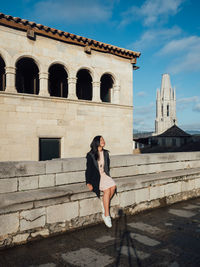 Woman in front of historic building against sky