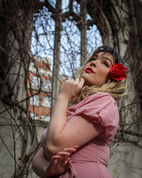 Girl looking away while standing on tree