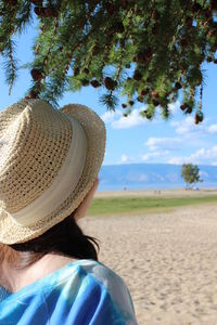 Rear view of woman wearing sun hat on field