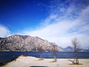 Scenic view of sea and mountains against blue sky