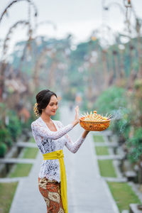 Side view of young woman holding flower