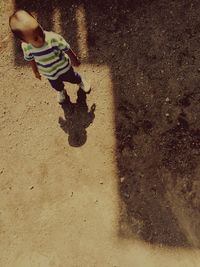 Low section of boy with horse in sand