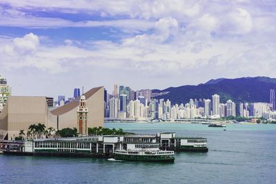 Boats in bay against buildings in city