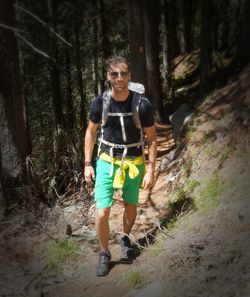 Full length portrait of young man standing in forest