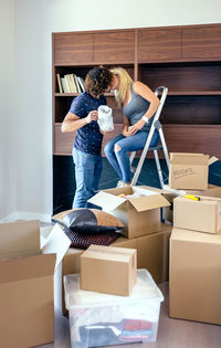Young couple kissing by cardboard boxes at home