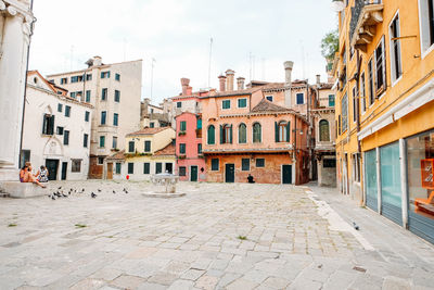 Houses by street in town against sky