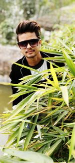 Portrait of young man wearing sunglasses standing outdoors