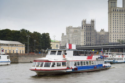 Boat in river against buildings in city