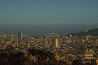 High angle view of buildings by sea against clear sky