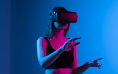 Young woman using virtual reality simulator at studio