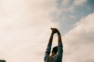 Low angle view of silhouette people standing against sky