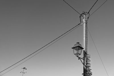 Low angle view of power lines against clear sky