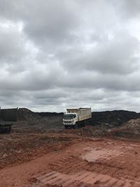 Road on field against cloudy sky