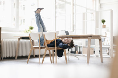 Woman doing gymnastics on chairs in a loft