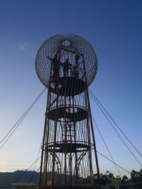 Low angle view of communications tower against blue sky