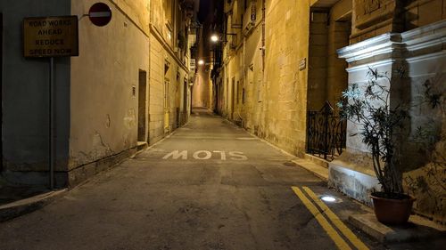 Illuminated alley amidst buildings in city at night