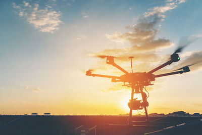 Low angle view of airplane flying against sky during sunset