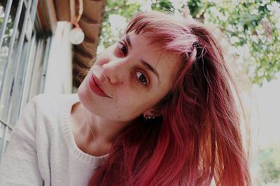 Low angle portrait of young woman with dyed hair at backyard
