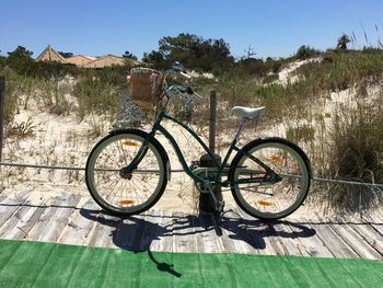 Bicycle parked on field against clear sky