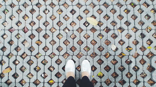 Low section of woman standing on footpath