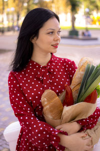 Portrait of young woman holding plant