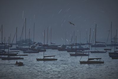 Sailboats in sea against sky at night