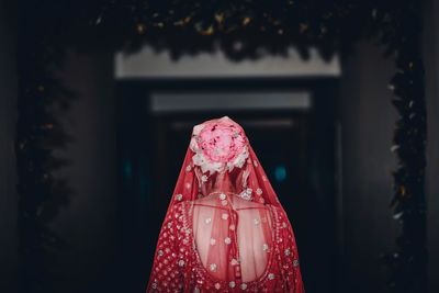 Rear view of bride wearing flowers while standing at doorway