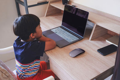 Boy using laptop at table