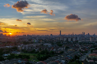 Aerial view of buildings in city during sunset