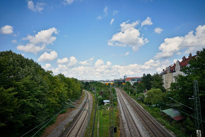 Railroad tracks in city against sky