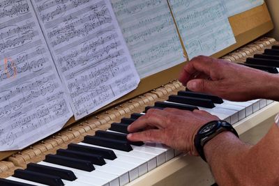 Midsection of man playing piano