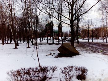 Bare trees on snow covered landscape