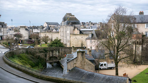 High angle view of buildings by river against sky