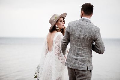 Bride and bridegroom standing at beach during wedding ceremony