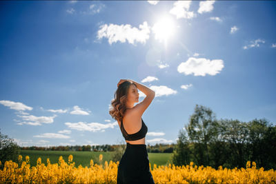 Rapeseed field, yellow field, forest, spring day, romantic date, blue sky, black trousers