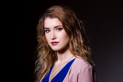 Portrait of woman against black background
