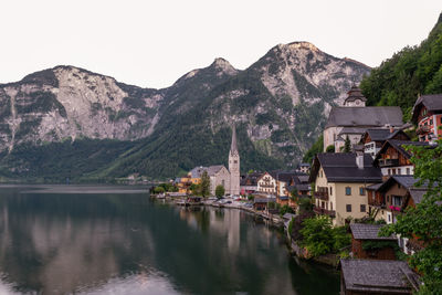 Town by lake and mountains against sky