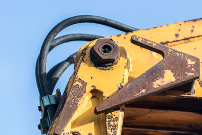 Low angle view of rusty metal against clear blue sky