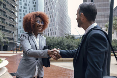 Two business colleagues shaking hands outdoors