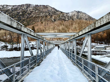 Footbridge over snow covered mountains