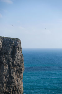 Scenic view of rock formation in sea against sky