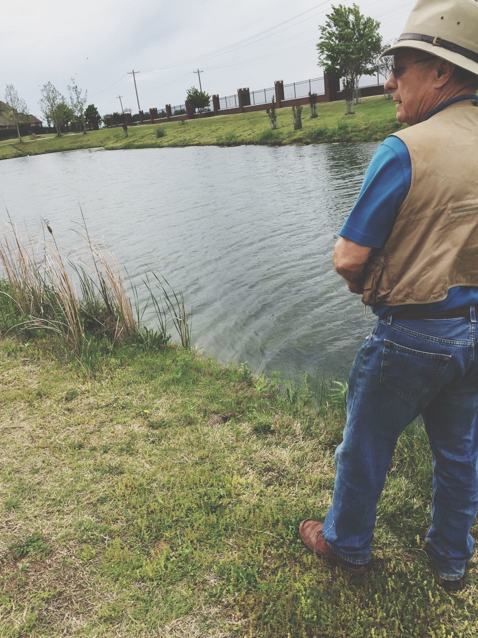 water, lifestyles, leisure activity, low section, person, lake, men, grass, casual clothing, standing, sky, river, reflection, nature, outdoors, sitting, day