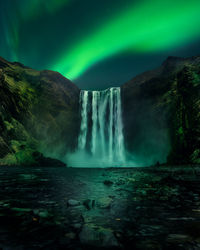 Scenic view of waterfall against sky at night