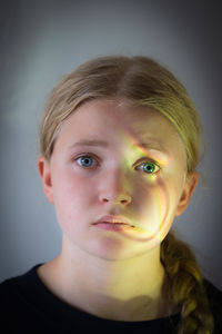 Portrait of girl standing against wall